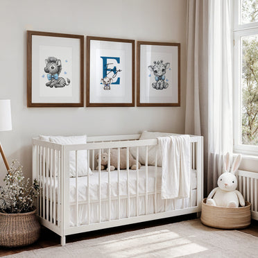 Set of three A4 prints in the style of pencil drawings. Each print features a cartoon baby giraffe, baby elephant, and baby zebra in black and white. They all wear a blue bow, with a few small blue hearts in the background. The middle image contains the elephant, which is smaller than the other two images. In the background, there is a large initial with a personalised name in black.