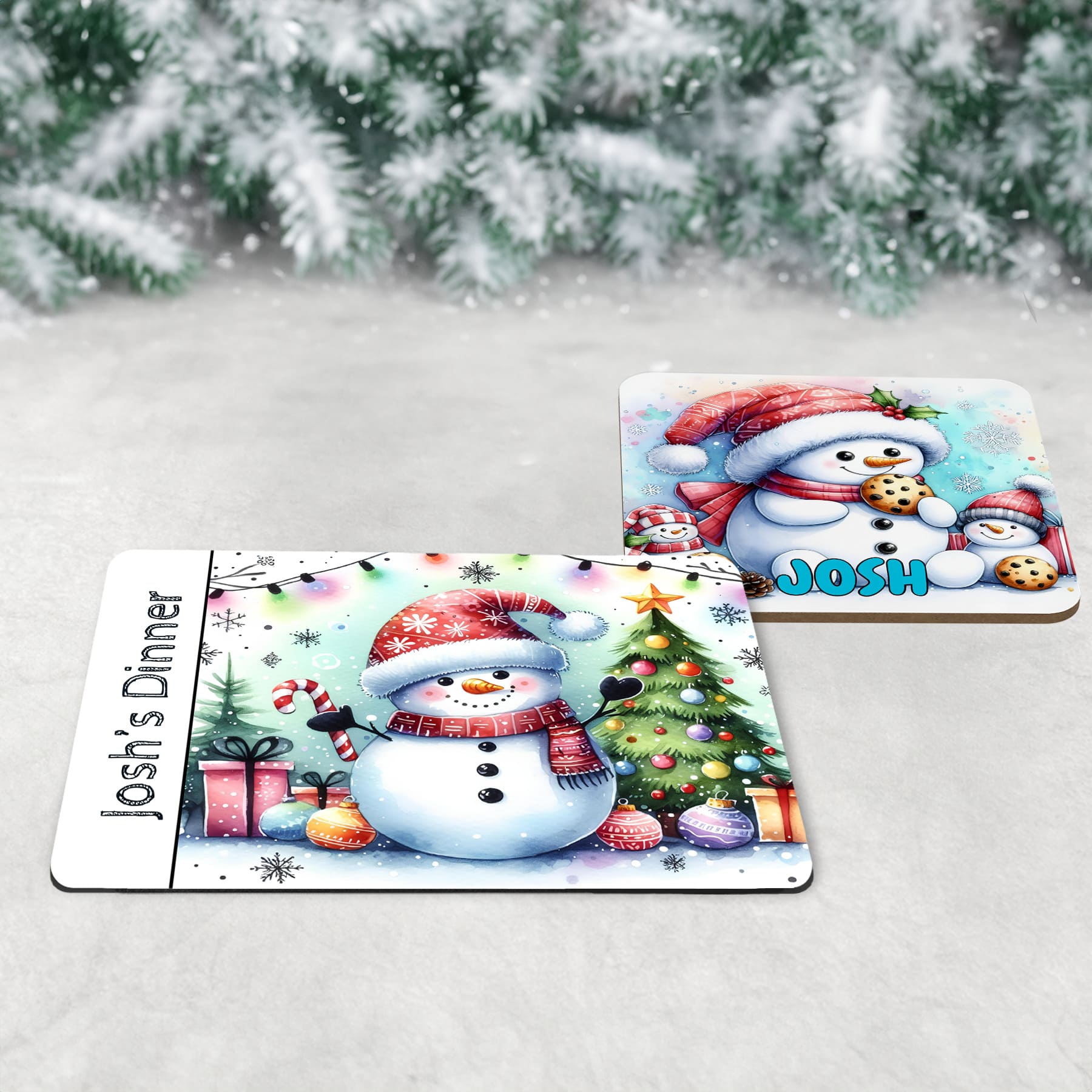 3 piece childrens Christmas dinner table set - a placemat, coaster and mug featuring bright and fun snowman designs, one drinking hot chocolate, one eating cookies and one with a tree and decorations. All personalised with childs name
