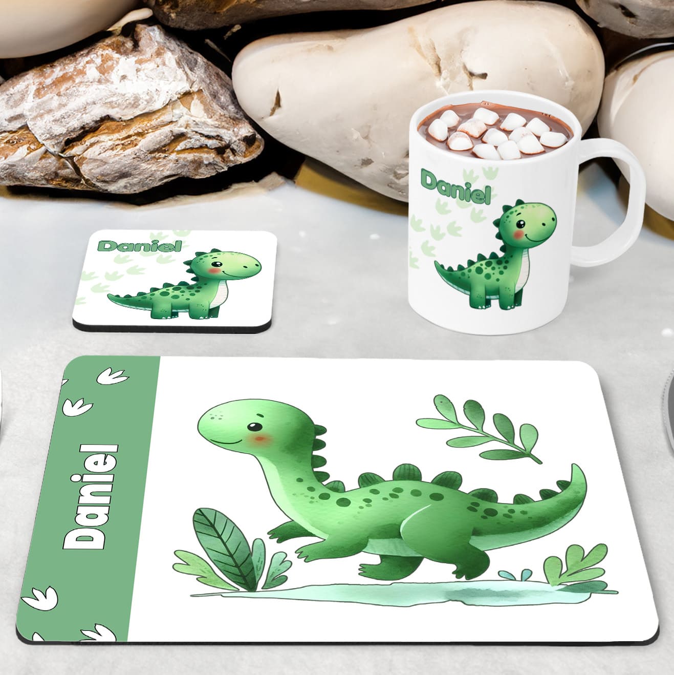 White Placemat, Mug and Coaster Set with cute playful green dinosaur design with plants and dinosaur prints. Personalised with Childs name