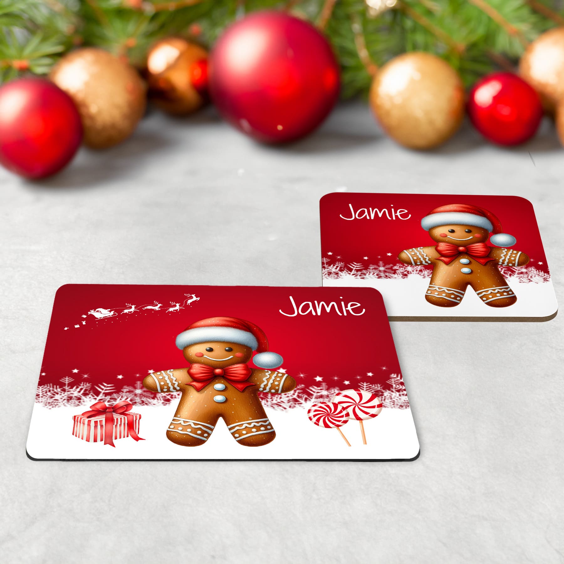 Kids Christmas Table Wear Set. A white mug featuring bright, bold gingerbread man design. Coaster and placemat have similar design on a bright red background. All personalised with childs name
