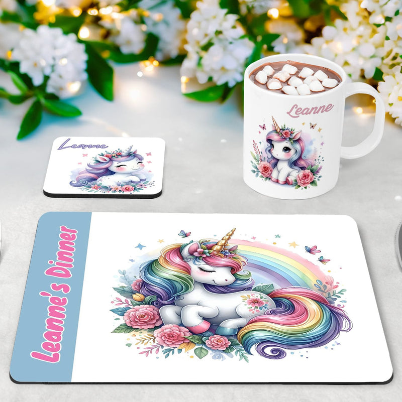 Whimsical flowery unicorn designs in lilacs, baby blue and pinks on a white placemat, mug and coaster set. Personalised with your childs name