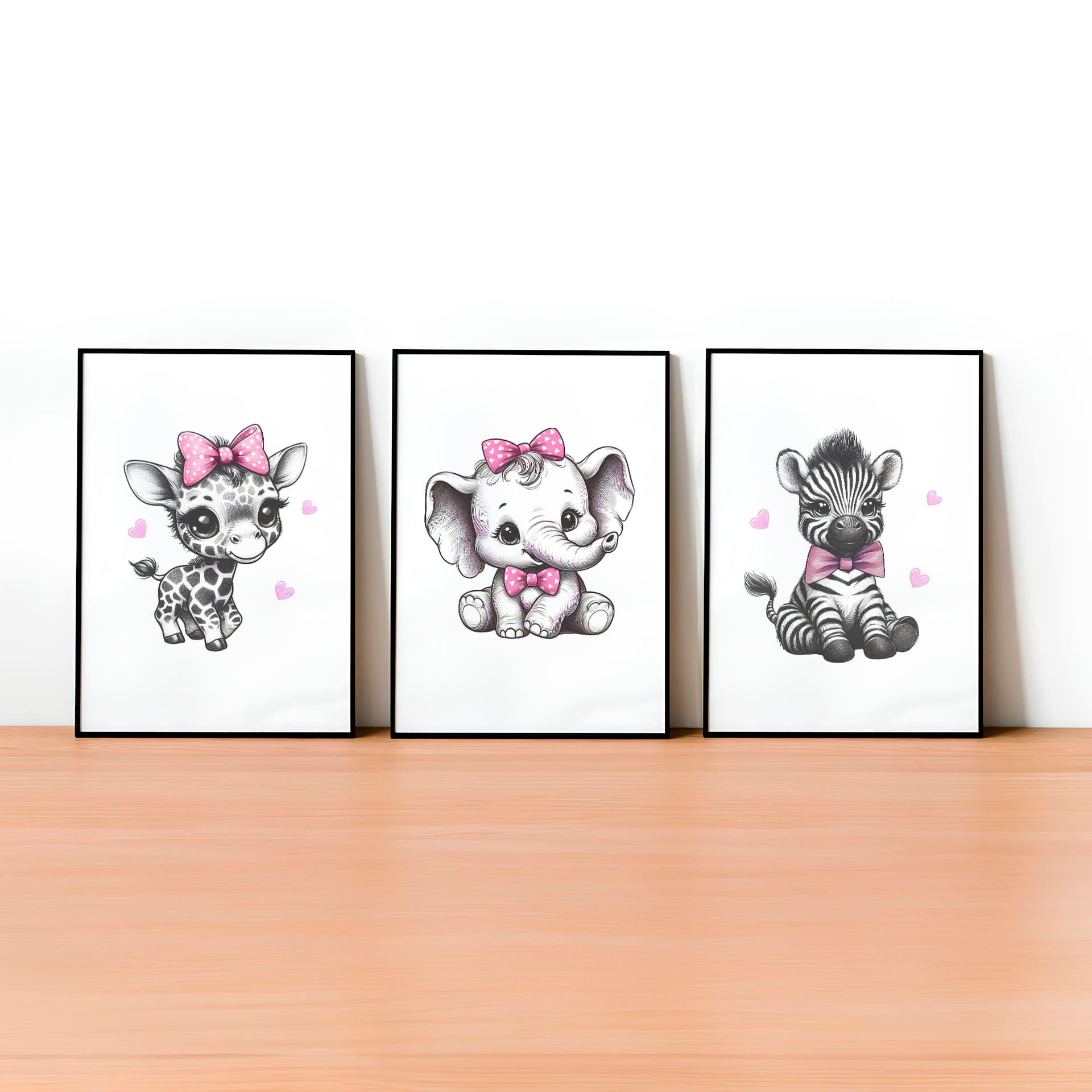 Set of three A4 prints in the style of pencil drawings. Each print features a cartoon baby giraffe, baby elephant, and baby zebra in black and white. They all wear a pink bow, with a few small pink hearts in the background.