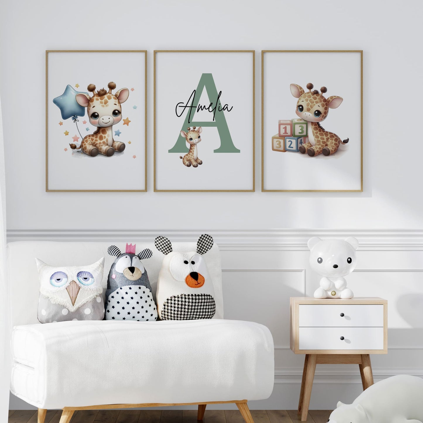 Set of three A4 prints in watercolour style. Each print depicts a cartoon baby giraffe In the first print, the giraffe sits by counting blocks; in the second, it holds a balloon. The middle giraffe is smaller than the other two, with a large initial in the background. A personalised name in black overlays the initial.