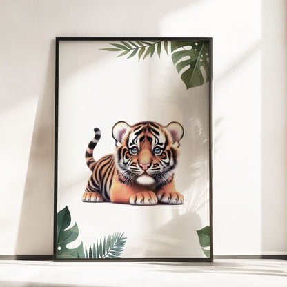 Set of three A4 prints featuring baby big cats - lion cub, tiger cub, and cheetah cub. The animals are depicted in a cartoony, bright style, resembling coloured pencil drawings. Jungle-style leaves adorn the edges of the prints. The middle print features a smaller animal compared to the others, with a large initial letter in the background. A personalised name in black overlays the initial letter.