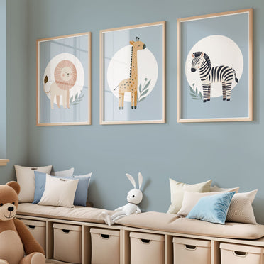 Set of three A4 prints featuring minimalist illustrations in muted tones. Each print depicts a different animal: a lion, a zebra, and a giraffe. The background is pale blue with a white circle on which the animal is overlaid.