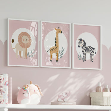 Set of three A4 prints featuring minimalist illustrations in muted tones. Each print depicts a different animal: a lion, a zebra, and a giraffe. The background is dusty pink with a white circle on which the animal is overlaid.