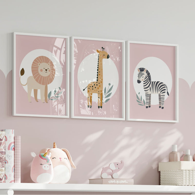 Set of three A4 prints featuring minimalist illustrations in muted tones. Each print depicts a different animal: a lion, a zebra, and a giraffe. The background is dusty pink with a white circle on which the animal is overlaid.