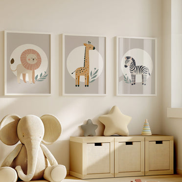 Set of three A4 prints featuring minimalist illustrations in muted tones. Each print depicts a different animal: a lion, a zebra, and a giraffe. The background is tan coloured with a white circle on which the animal is overlaid.