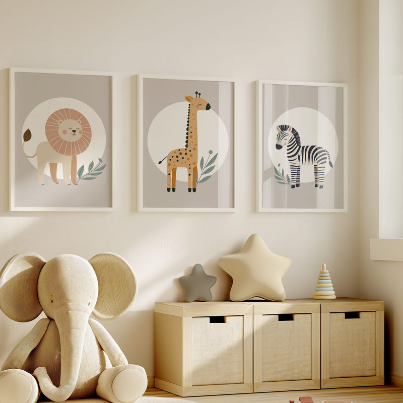 Set of three A4 prints featuring minimalist illustrations in muted tones. Each print depicts a different animal: a lion, a zebra, and a giraffe. The background is tan coloured with a white circle on which the animal is overlaid.