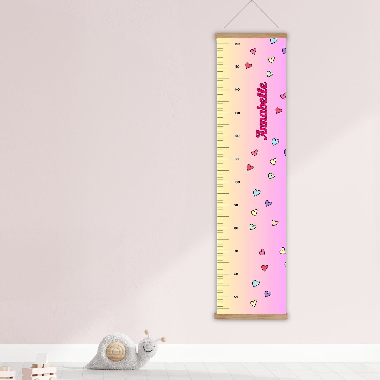 Childs height chart in yellow & pink with colourful love hearts and personalised with your childs name in vibrant pink. Available on black, white or natural hanger