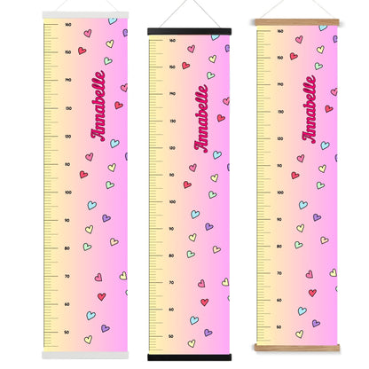 Childs height chart in yellow & pink with colourful love hearts and personalised with your childs name in vibrant pink. Available on black, white or natural hanger