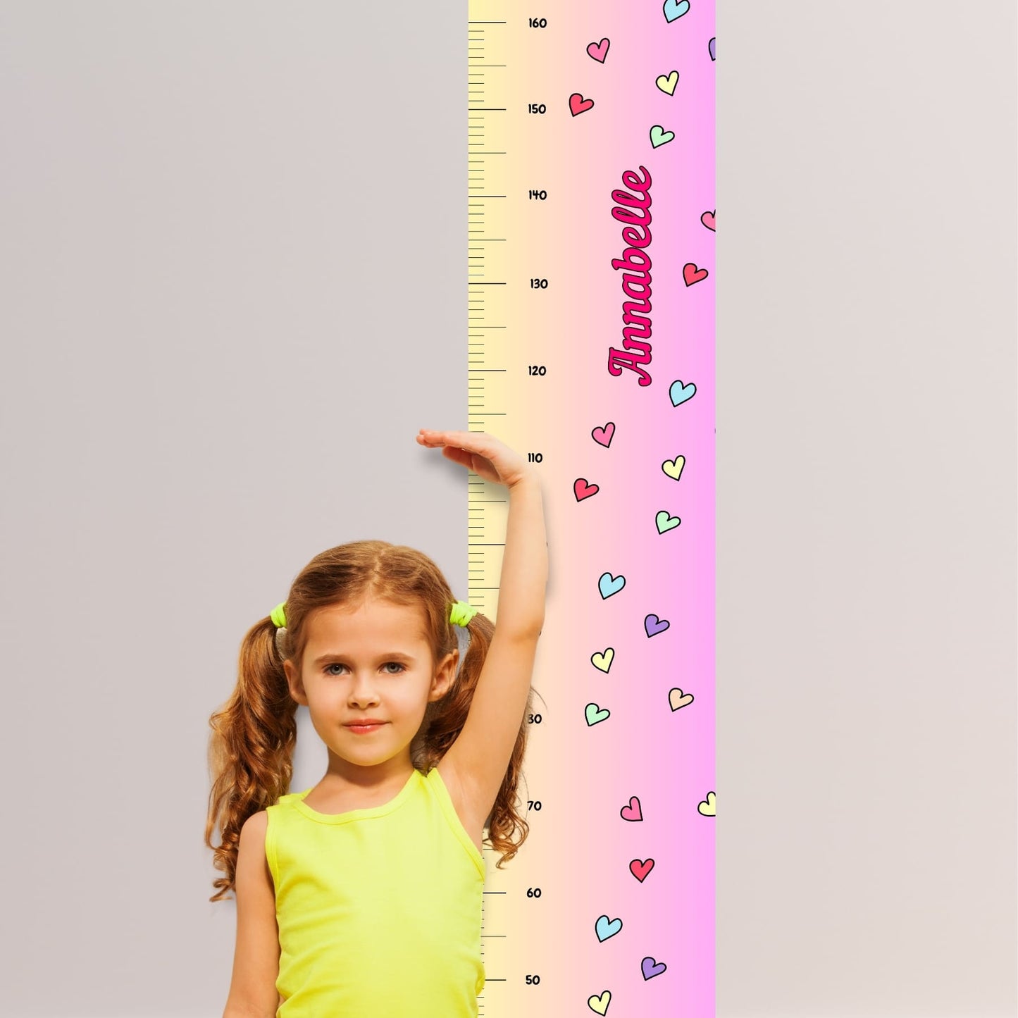 Childs height chart in yellow & pink with colourful love hearts and personalised with your childs name in vibrant pink. Available on black, white or natural hanger