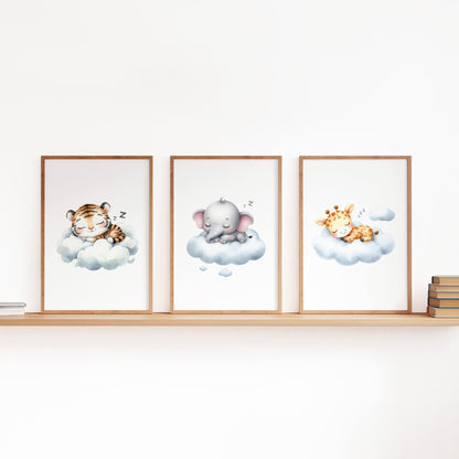 Set of three A4 prints in watercolour style. The first print shows a baby tiger sleeping on a cloud, the second depicts a baby elephant sleeping on a cloud, and the third features a baby giraffe sleeping on a cloud.