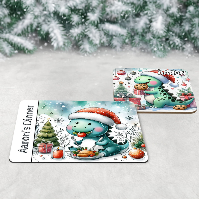 Unique Christmas Dinner Set for Children. Featuring a placemat with a dinosaur eating Christmas dinner, a coaster with a dinosaur eating cookies and a mug with a dinosaur drinking hot chocolate. All personalised with childs name