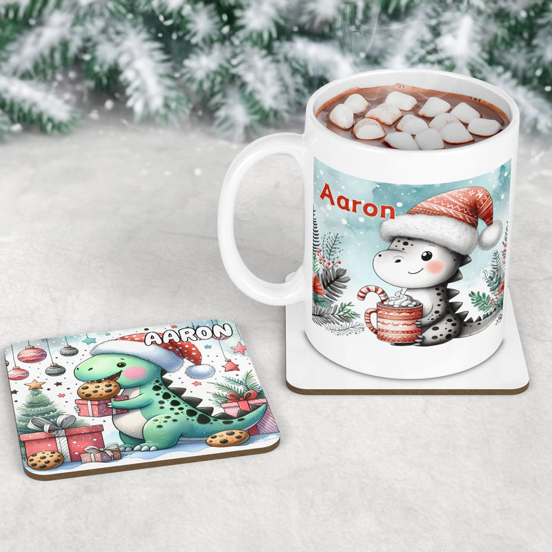 Unique Christmas Dinner Set for Children. Featuring a placemat with a dinosaur eating Christmas dinner, a coaster with a dinosaur eating cookies and a mug with a dinosaur drinking hot chocolate. All personalised with childs name