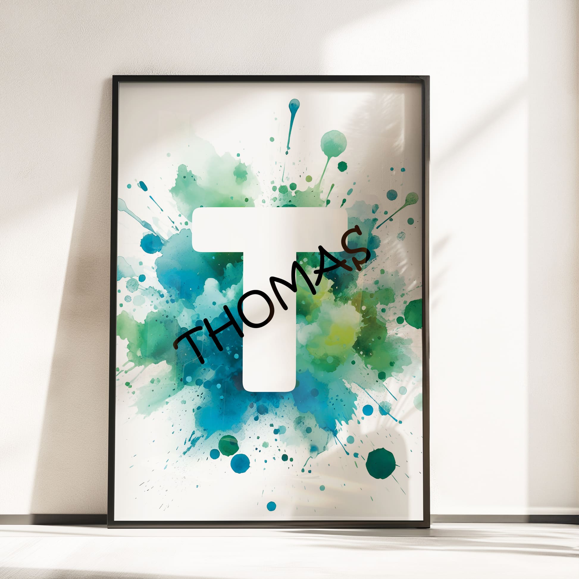 Set of 2 green/blue prints for children's nursery décor. One print feature vibrant, green/blue dinosaur in watercolour effects, while the second showcases watercolour splashes with a white initial letter and personalised black name