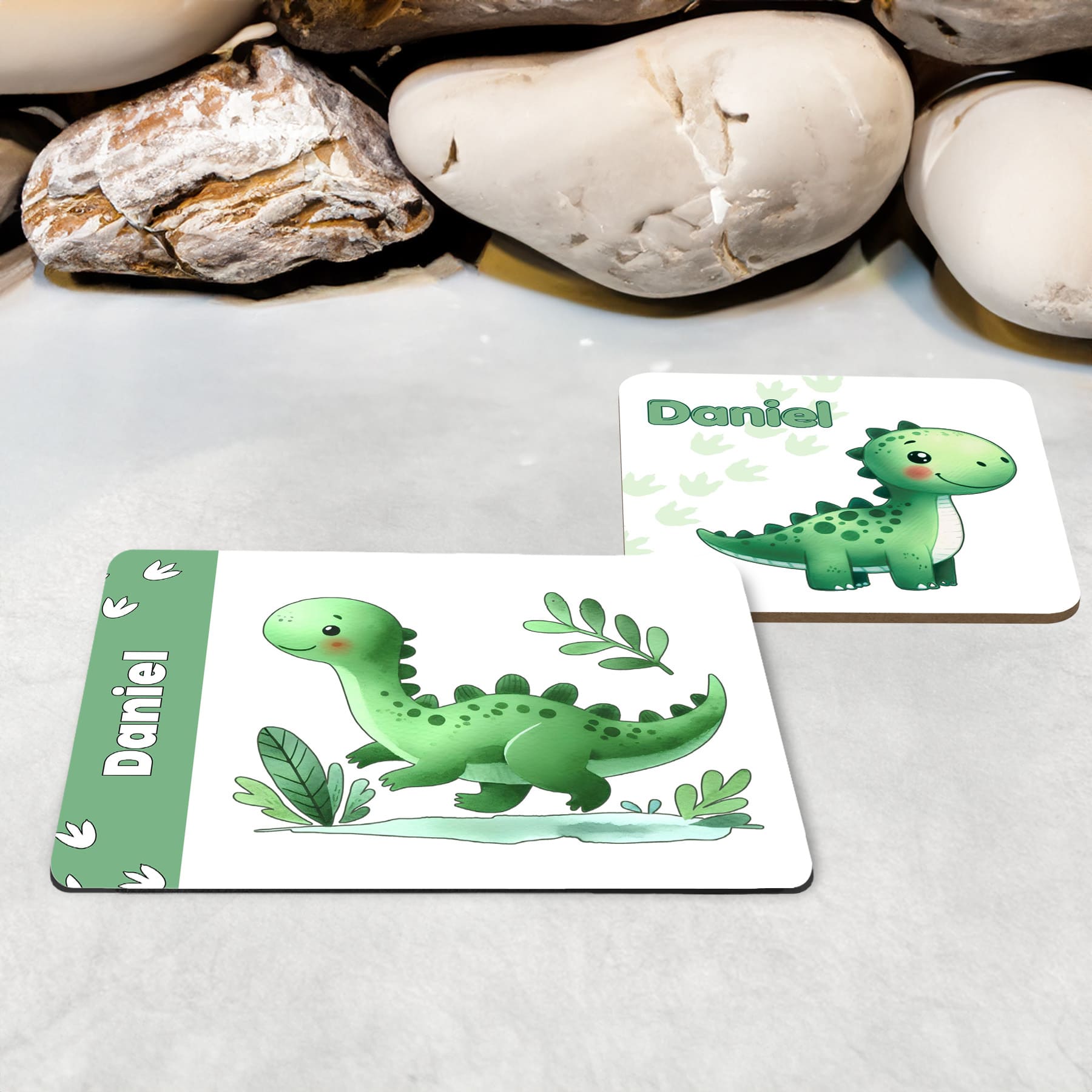 White Placemat and Coaster Set with cute playful green dinosaur design with plants and dinosaur prints. Personalised with Childs name