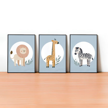 Set of three A4 prints featuring minimalist illustrations in muted tones. Each print depicts a different animal: a lion, a zebra, and a giraffe. The background is pale blue with a white circle on which the animal is overlaid.