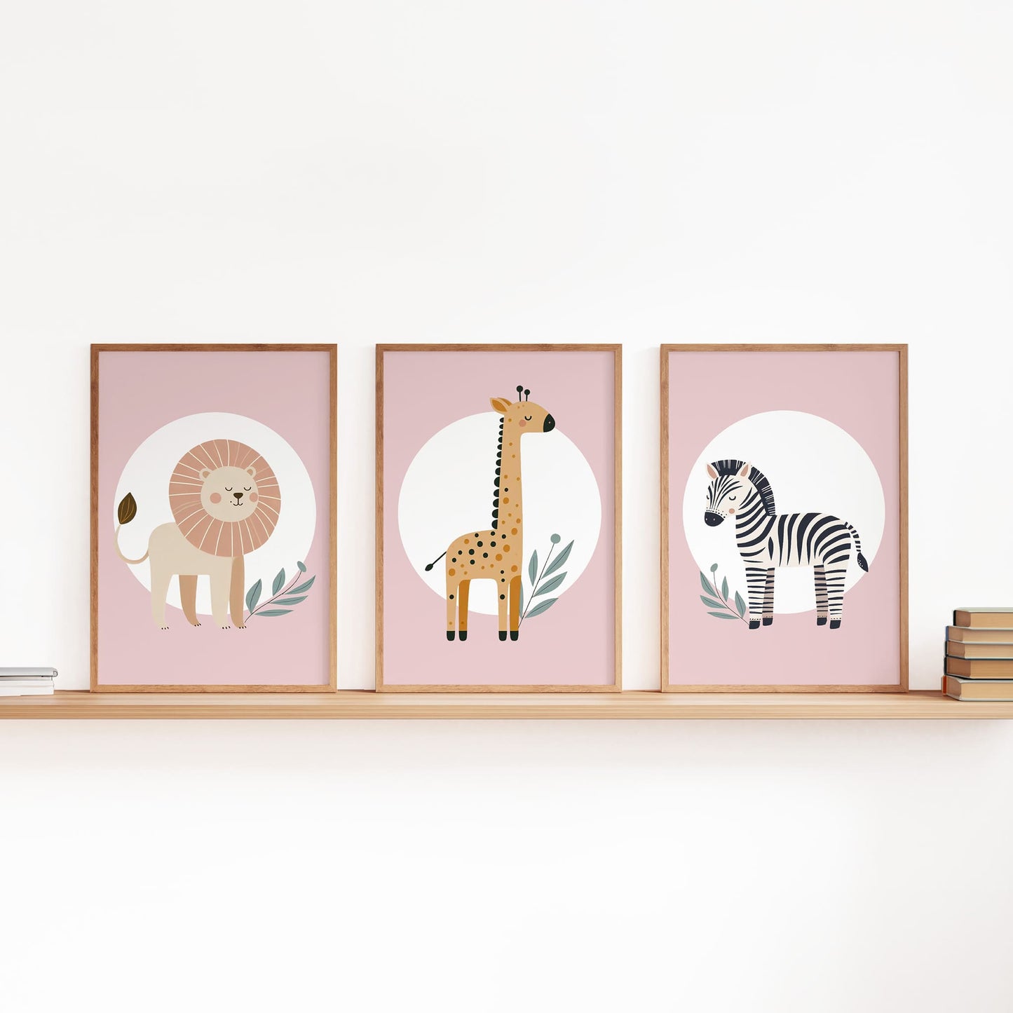 Set of three A4 prints featuring minimalist illustrations in muted tones. Each print depicts a different animal: a lion, a zebra, and a giraffe. The background is dusty pink with a white circle on which the animal is overlaid.