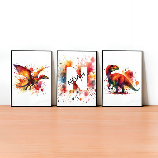 Set of 3 dinosaur prints for children's nursery décor. Two prints feature vibrant, red and yellow dinosaurs in watercolour effects, while the third showcases watercolour splashes with a white initial letter and personalised black name