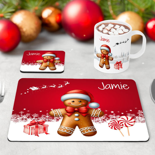 Kids Christmas Table Wear Set. A white mug featuring bright, bold gingerbread man design. Coaster and placemat have similar design on a bright red background. All personalised with childs name