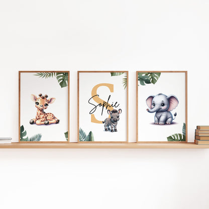 Set of  three A4 prints featuring cartoony and brightly illustrated safari animals – an elephant, giraffe, and zebra. The animals are depicted in the style of coloured pencil drawings with jungle-style leaves adorning the edges of the prints. The middle print features a smaller animal compared to the others, with a large initial letter in the background. A personalised name is overlaid in black across the initial letter