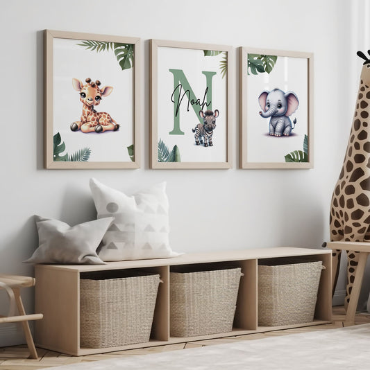 Set of three A4 prints featuring cartoony and brightly illustrated safari animals – an elephant, giraffe, and zebra. The animals are depicted in the style of coloured pencil drawings with jungle-style leaves adorning the edges of the prints. The middle print features a smaller animal compared to the others, with a large initial letter in the background. A personalised name is overlaid in black across the initial letter