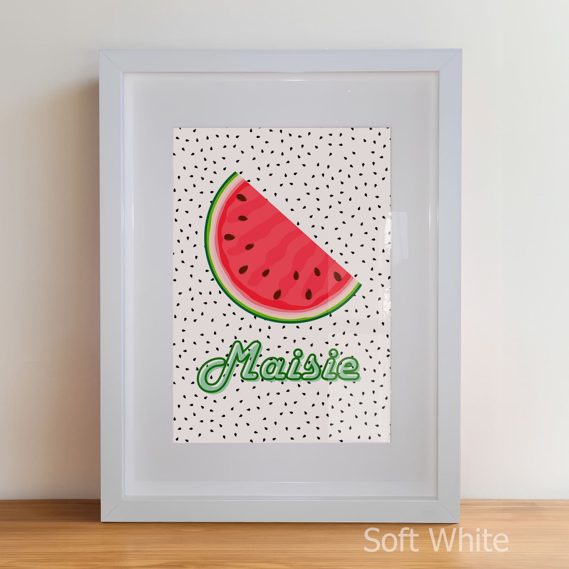 Framed artwork with a watermelon slice and the name 'Maisie' on a polka dot background.