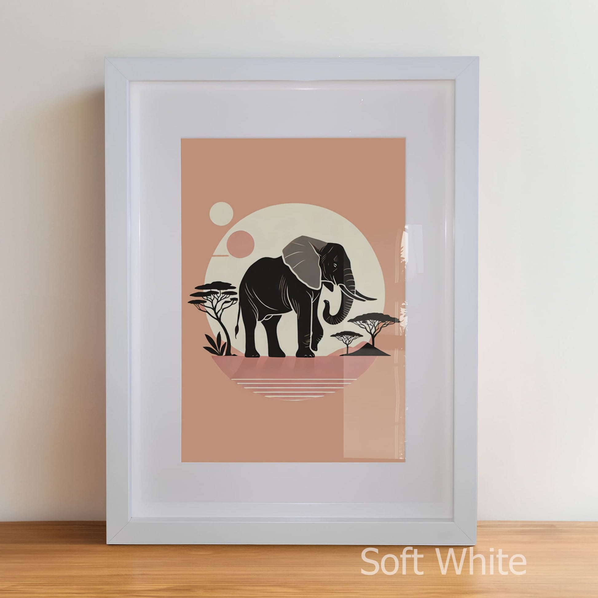 Framed artwork of an elephant with a sunset and trees on a peach background.