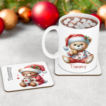 White mug and coaster set with cute teddy bear dressed in red and white christmas pyjamas, eating cookie and drinking hot chocolate. Personalised with childs name