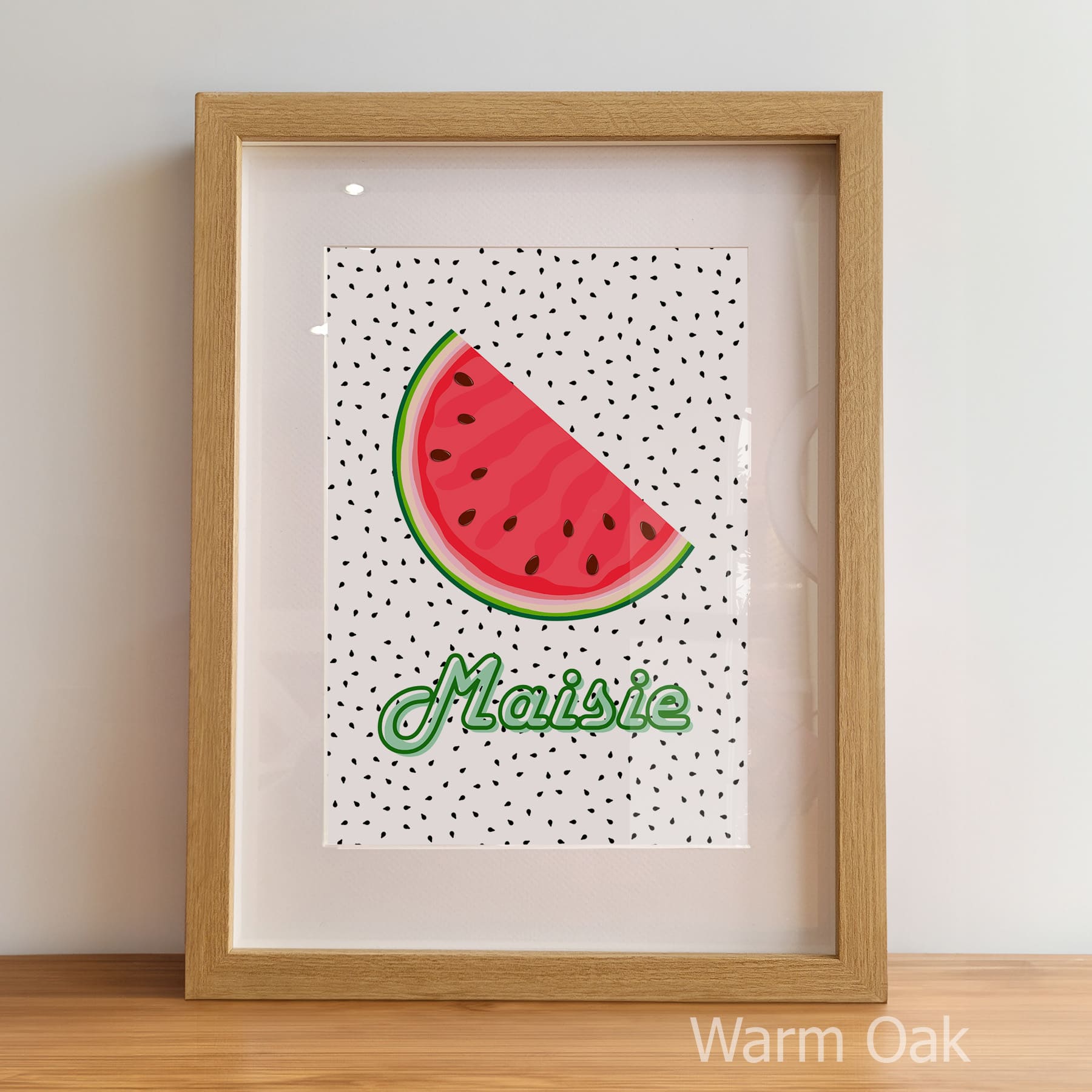 Framed artwork with a watermelon slice and the name 'Maisie' on a polka dot background.
