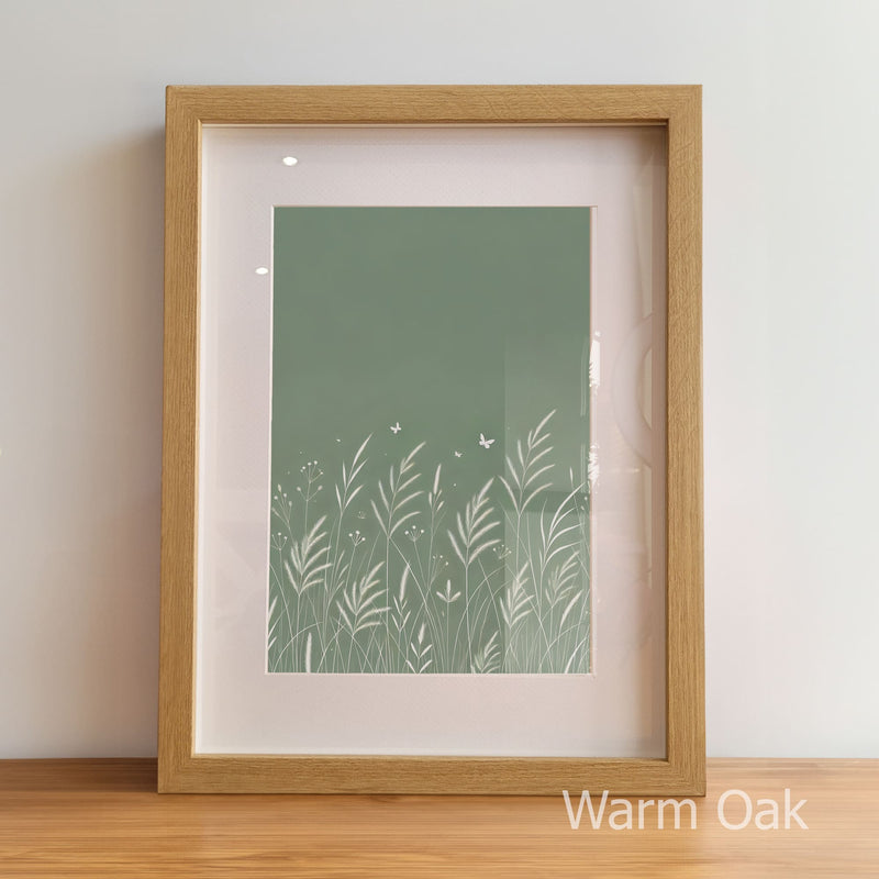 Framed artwork with a green nature-themed print inside, on a wooden floor.