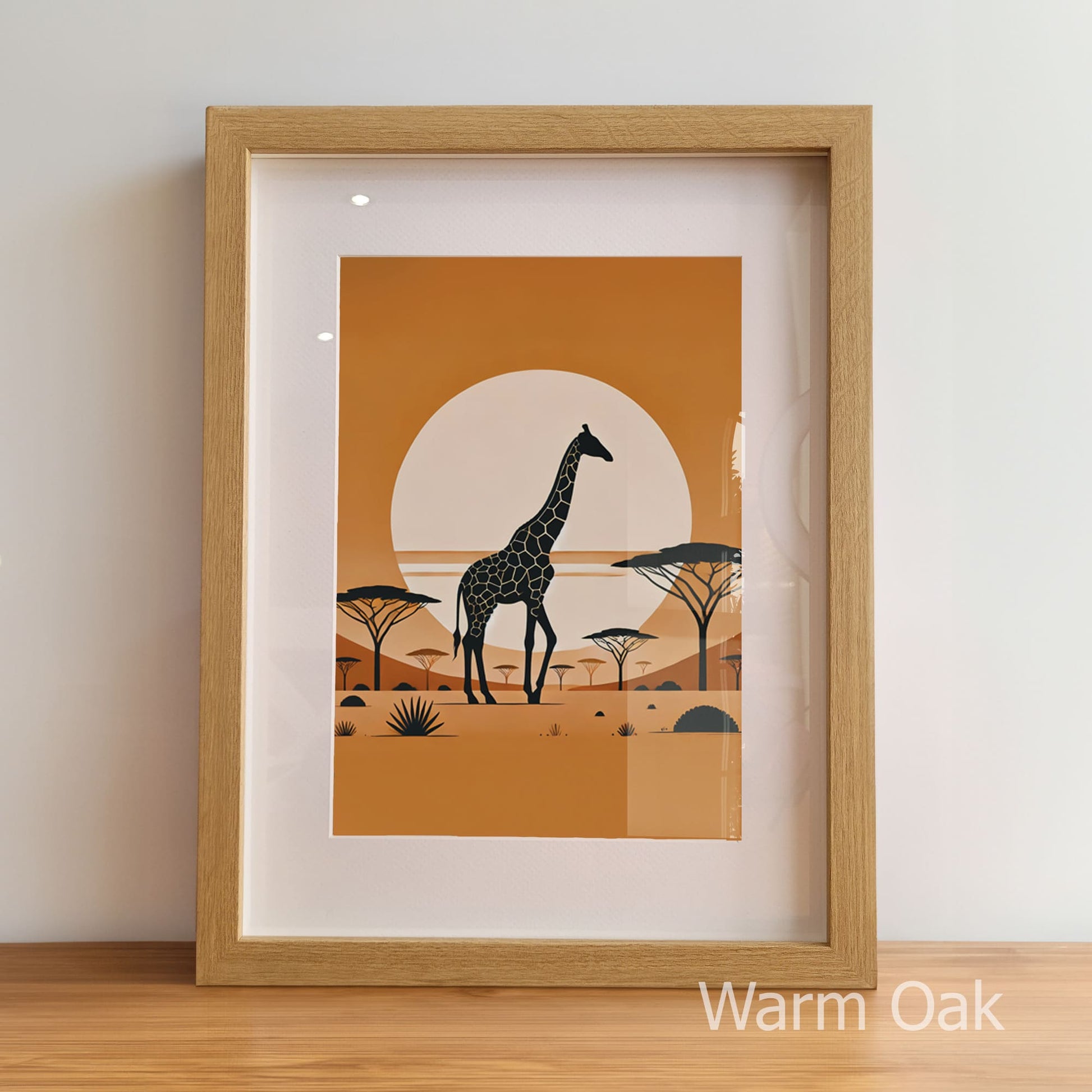 Framed artwork of a giraffe in a savanna scene with a warm orange background, displayed on a wooden floor.