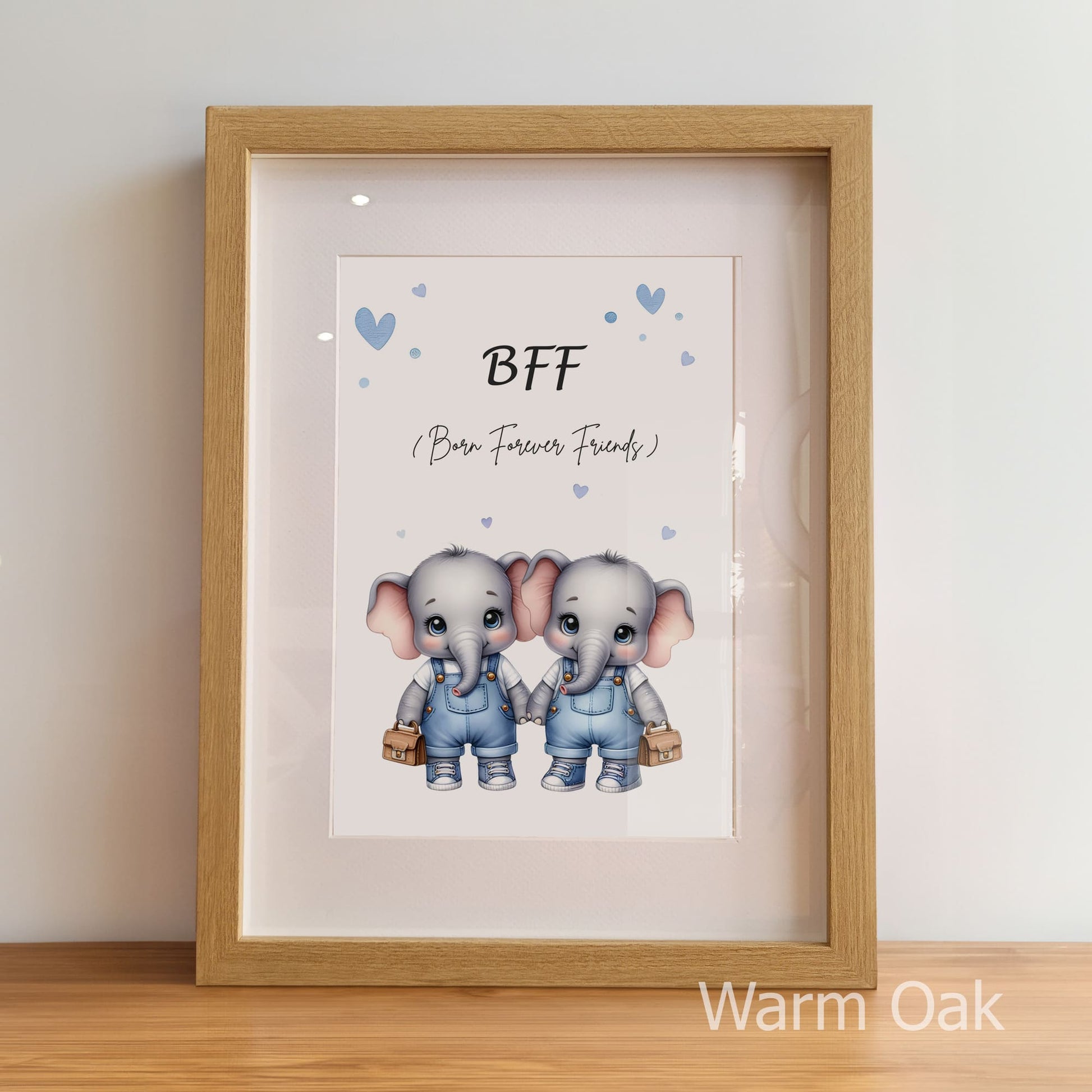Framed artwork with two elephants holding hands and the text 'BFF (Born Forever Friends)' on a light background.