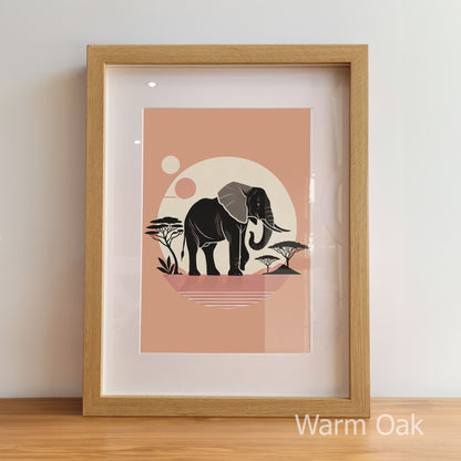Framed artwork with an elephant design on a peach background, displayed on a light wooden floor.