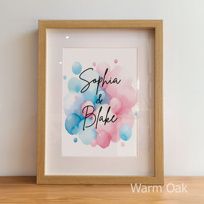 Framed artwork with 'Sophia & Blake' text on a watercolor background, displayed on a wooden surface.
