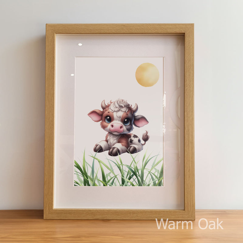 Framed artwork of a cute cow and calf in a grassy field with a warm oak frame.