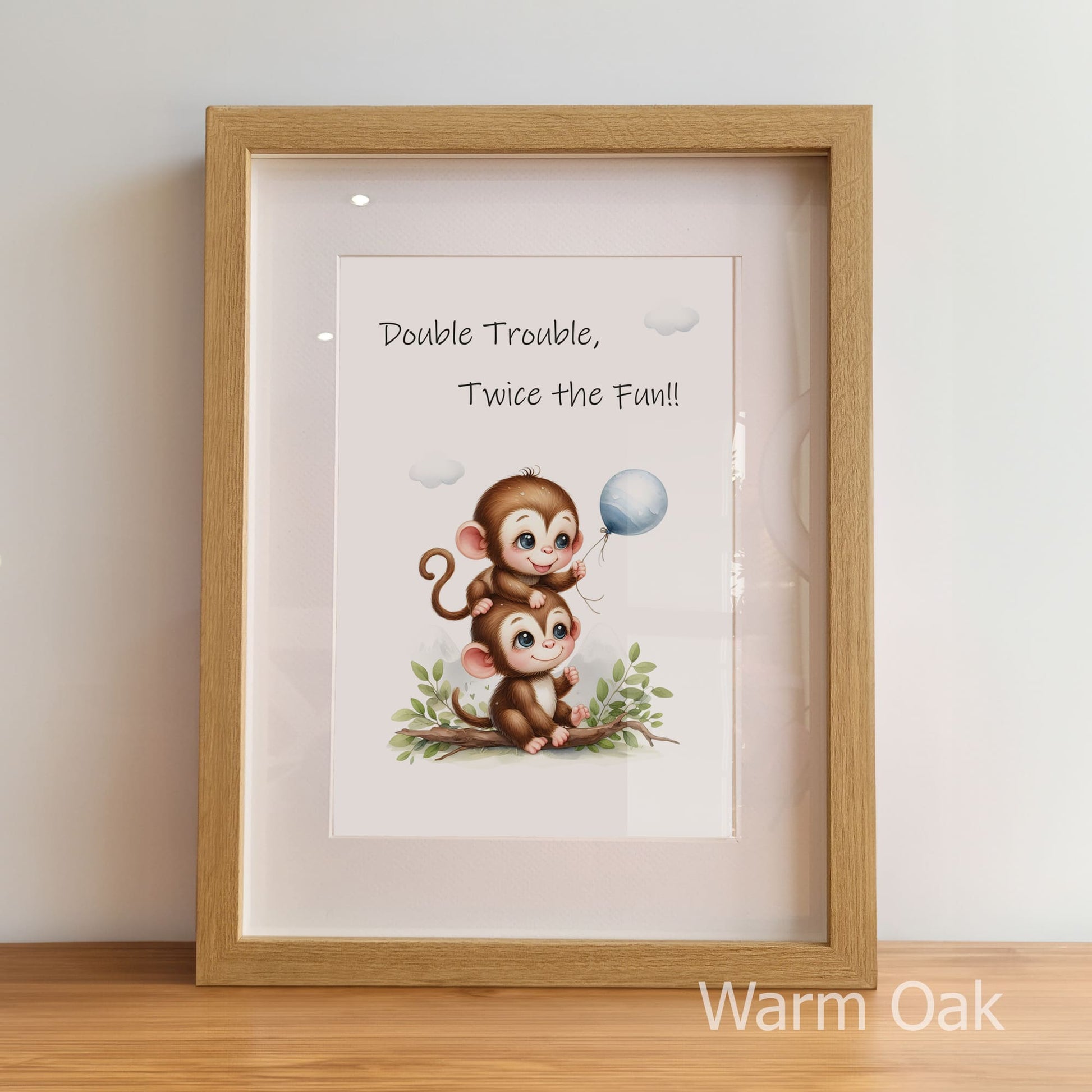 Framed print with cartoon monkeys and text 'Double Trouble, Twice the Fun!' in a warm oak frame.