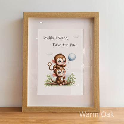 Framed print with cartoon monkeys and text 'Double Trouble, Twice the Fun!' in a warm oak frame.