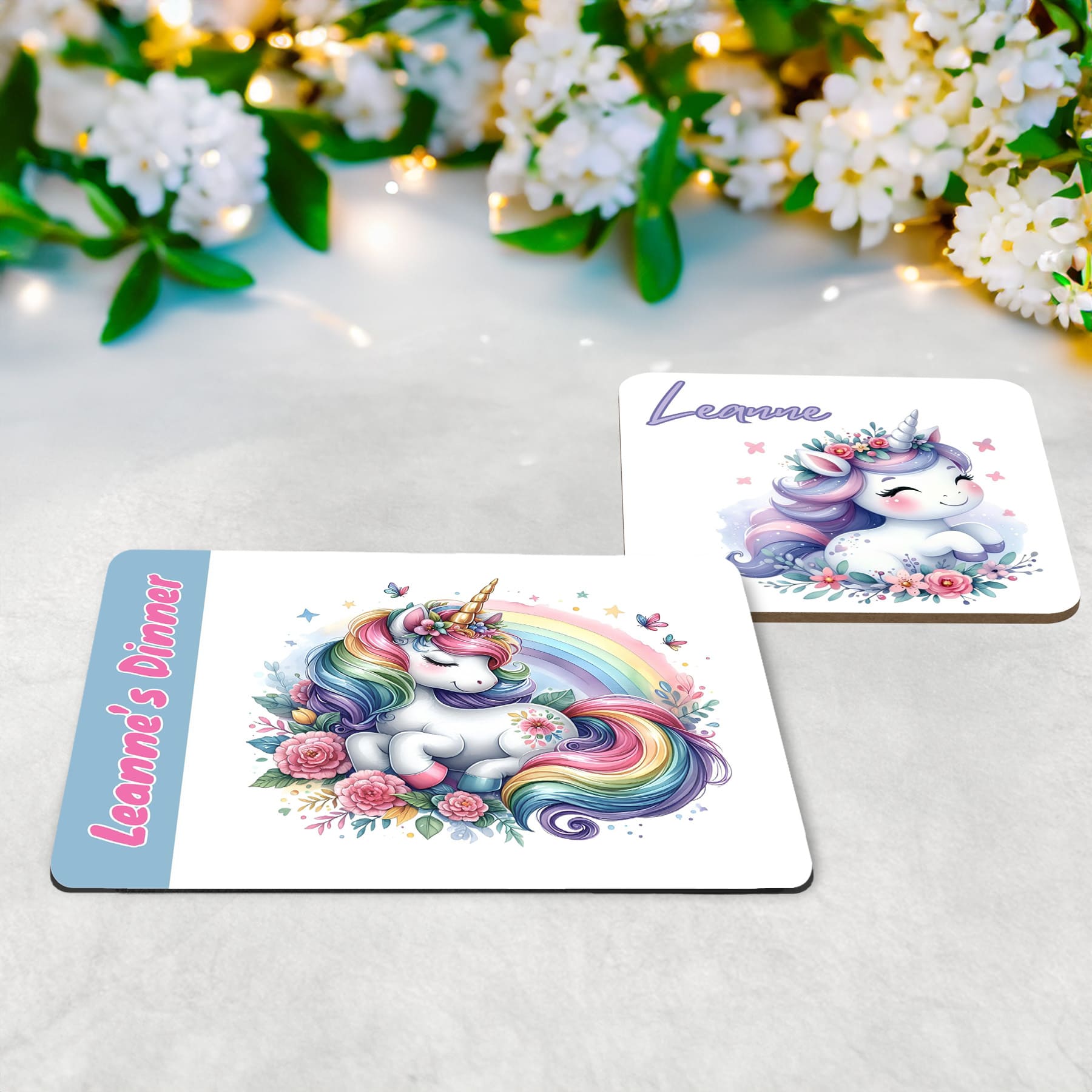 Whimsical flowery unicorn designs in lilacs, baby blue and pinks on a white placemat and coaster set. Personalised with your childs name