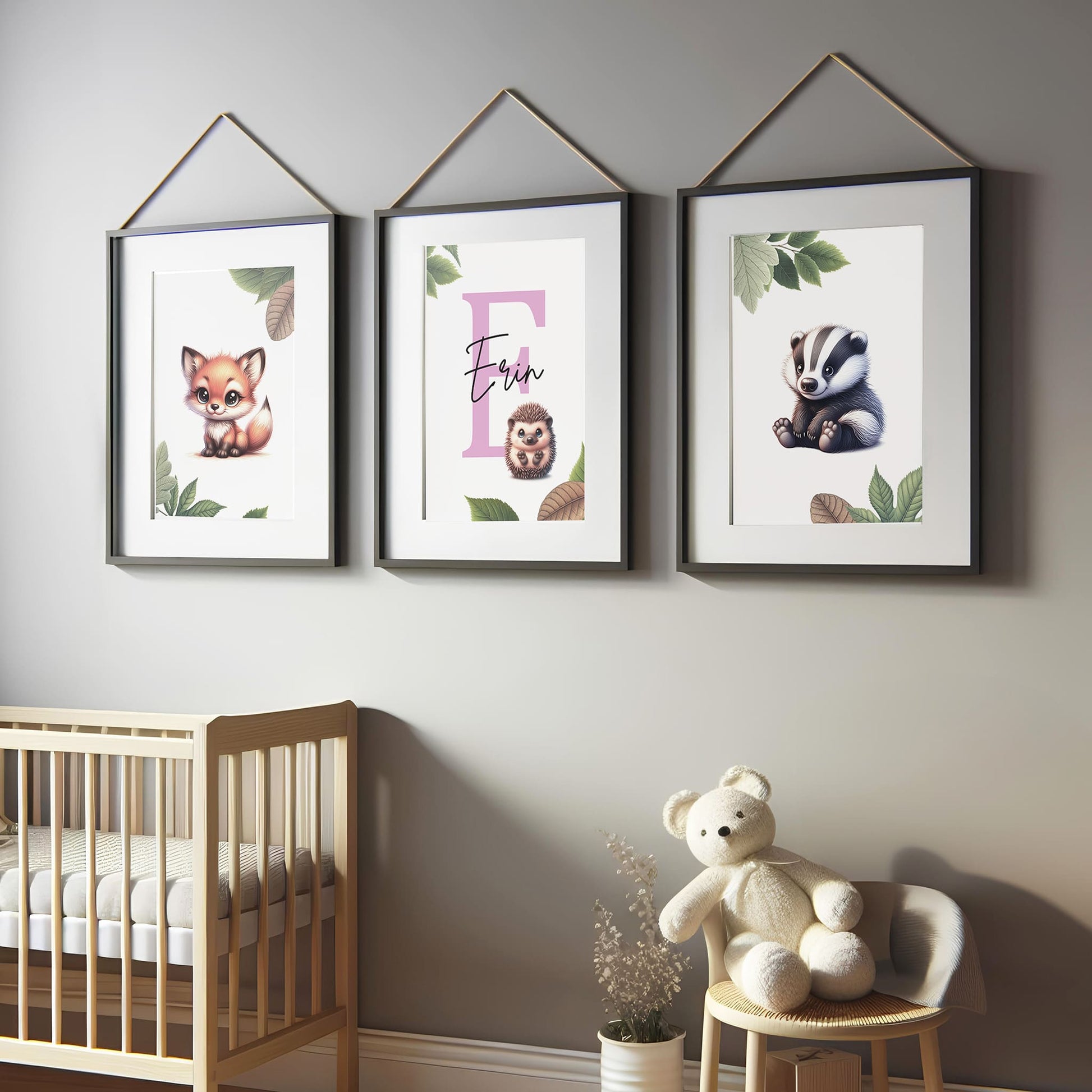 Set of three A4 prints featuring woodland baby animals - fox, badger, and squirrel. The animals are depicted in a cartoony style, resembling coloured pencil drawings. Woodland leaves decorate the edges of the prints. The middle print features a smaller animal than the others, with a large initial letter in the background. A personalised name in black overlays the initial letter.