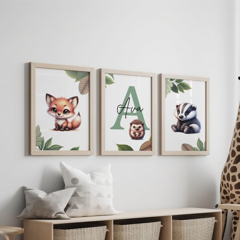 Set of three A4 prints featuring woodland baby animals - fox, badger, and squirrel. The animals are depicted in a cartoony style, resembling coloured pencil drawings. Woodland leaves decorate the edges of the prints. The middle print features a smaller animal than the others, with a large initial letter in the background. A personalised name in black overlays the initial letter.