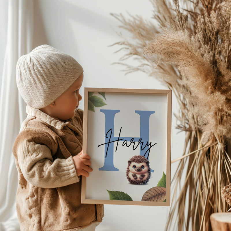 Set of three A4 prints featuring woodland baby animals - fox, badger, and squirrel. The animals are depicted in a cartoony style, resembling coloured pencil drawings. Woodland leaves decorate the edges of the prints. The middle print features a smaller animal than the others, with a large initial letter in the background. A personalised name in black overlays the initial letter.