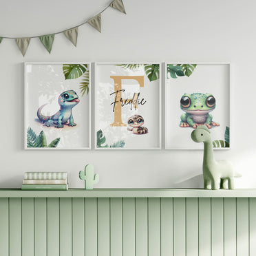 Set of three A4 prints featuring reptiles/amphibians - tree frog, lizard, and snake. The animals are depicted in a cartoony, bright style resembling coloured pencil drawings. Jungle-style leaves decorate the edges of the prints. The middle print features a smaller animal than the others, with a large initial letter in the background. A personalised name in black overlays the initial letter.